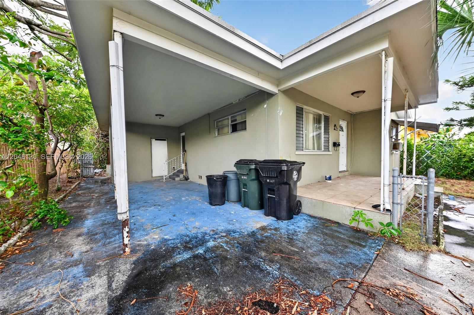 A concrete driveway leads to a covered carport and a small front porch of a house — 914 N K St, Lake Worth FL 33460, LAKE WORTH, FL