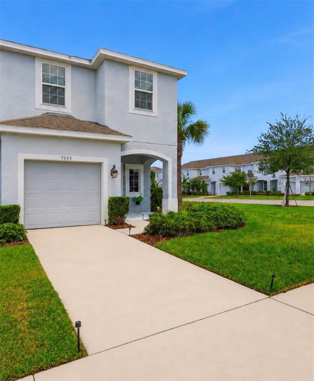 A light blue two-story townhouse with a single-car garage and a concrete driveway — 7005 GRAND ELM DRIVE, RIVERVIEW, FL