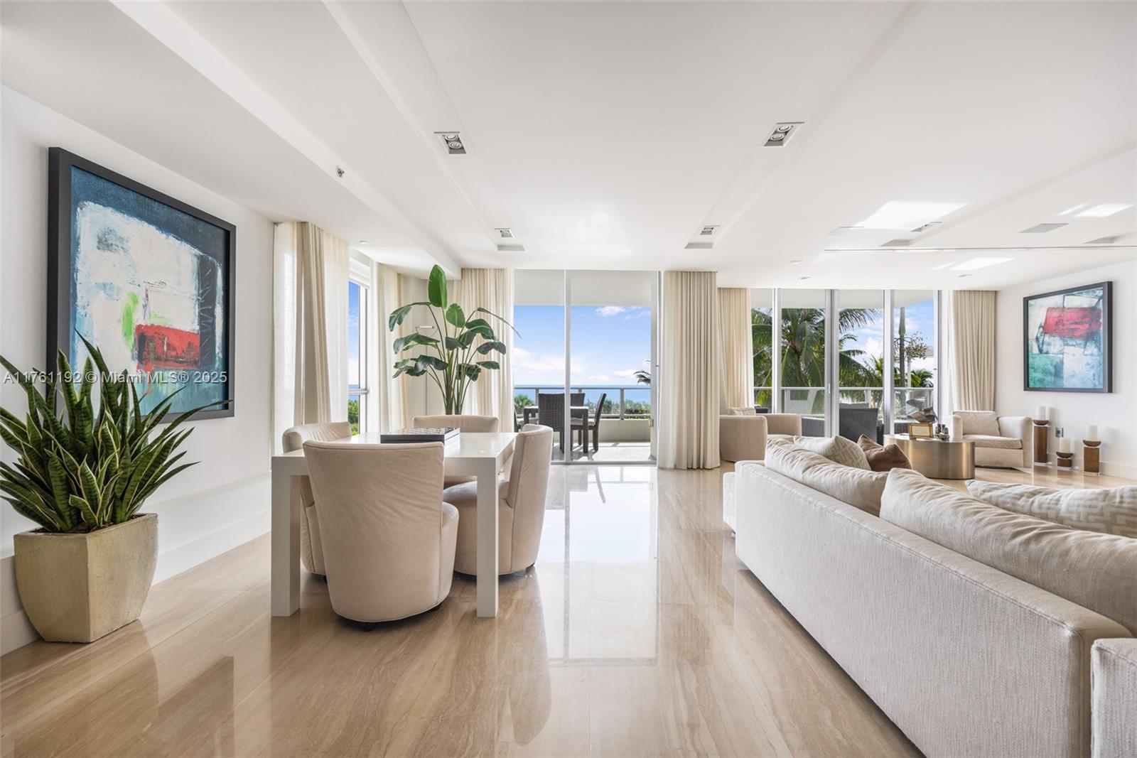 A bright, open-concept living and dining area features marble floors, neutral furniture, and ocean views — 125 Ocean Dr # 0303, Miami Beach FL 33139, MIAMI BEACH, FL