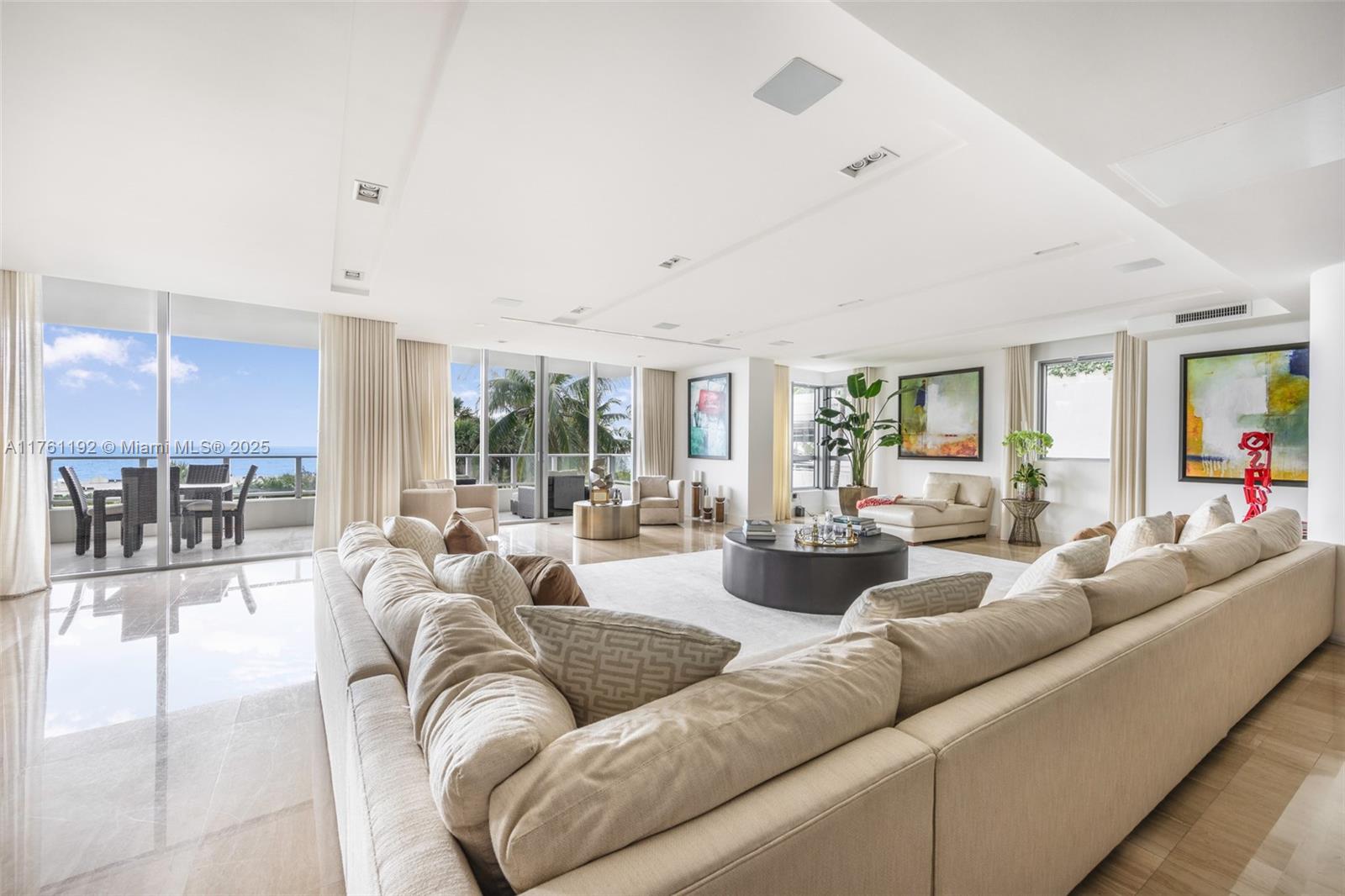 A spacious living room features a large sectional sofa, marble floors, and a balcony view — 125 Ocean Dr # 0303, Miami Beach FL 33139, MIAMI BEACH, FL
