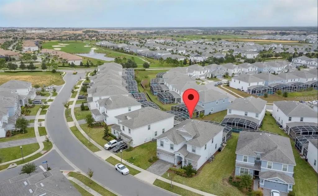 An aerial view shows a suburban neighborhood with houses, screened-in pools, and a golf course — 1537 MULLIGAN BOULEVARD, DAVENPORT, FL
