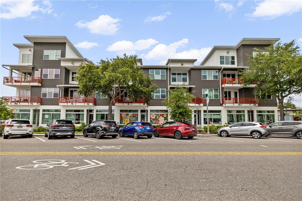 A multi-story apartment building with ground-floor retail spaces and a parking lot in front — 17 29TH STREET N Lot 8, ST PETERSBURG, FL