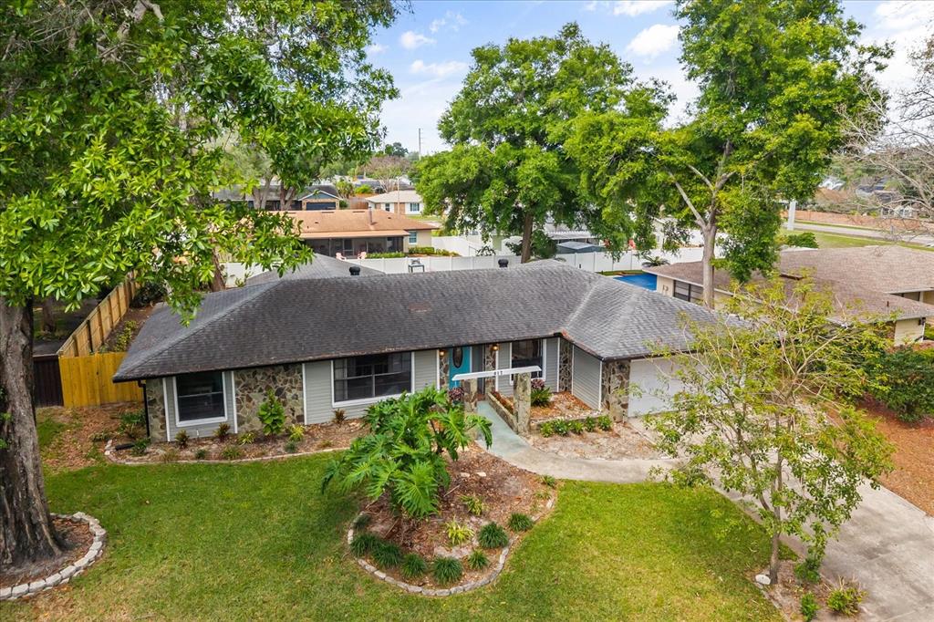 An elevated view of a single-story ranch house with stone accents and a gray roof — 817 E HARBOUR COURT, OCOEE, FL