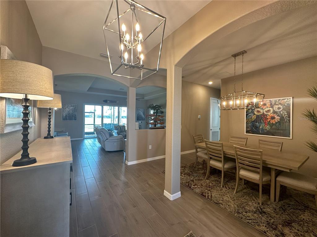 A dining room and entryway feature tile floors, modern light fixtures, and neutral wall colors — 25115 LONGMEADOW DRIVE, PUNTA GORDA, FL