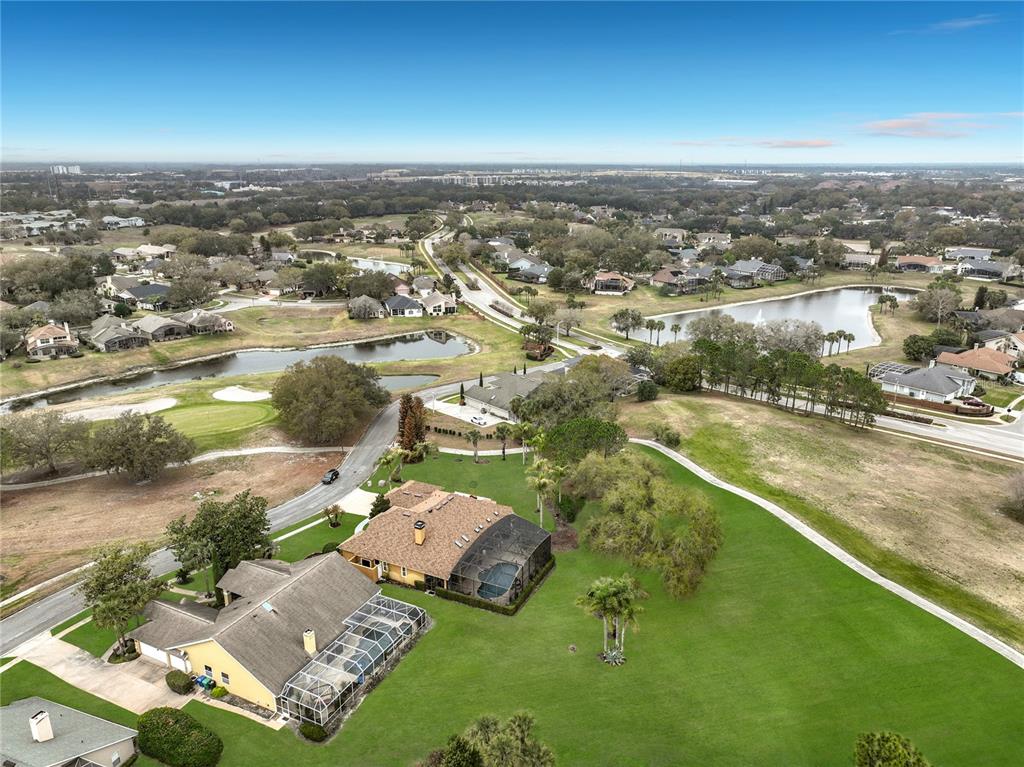 An aerial view shows two houses with screened-in pools situated on a large grassy lot — 635 CHOCKTAW STREET, LAKE MARY, FL