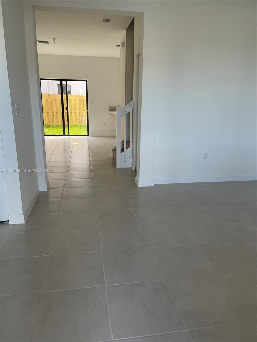 A tiled room leads to a staircase and a doorway opening to a backyard — 21447 NE 2nd Pl, Miami FL 33179, MIAMI, FL