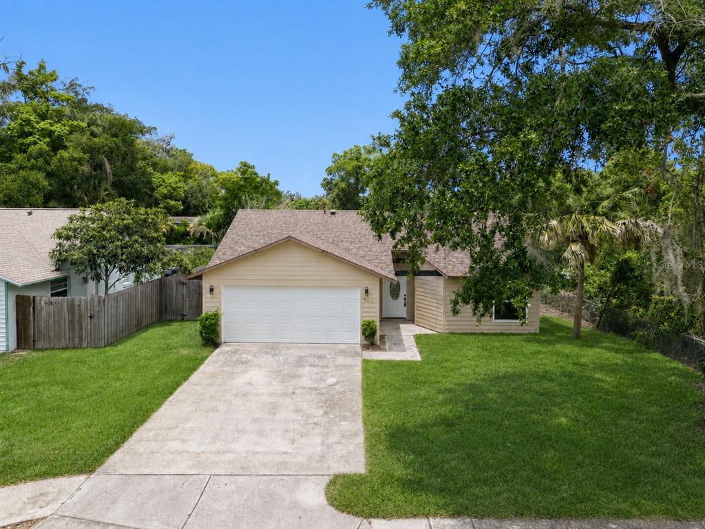 A single-story house with a beige exterior, a two-car garage, and a front lawn — 761 ROBINHOOD DRIVE, MAITLAND, FL