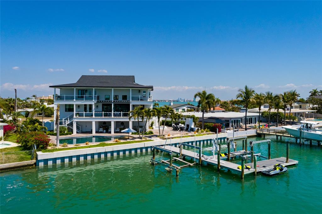 A multi-story waterfront house with a pool, dock, and boat lift on a canal — 5408 PALI WAY, ST PETE BEACH, FL