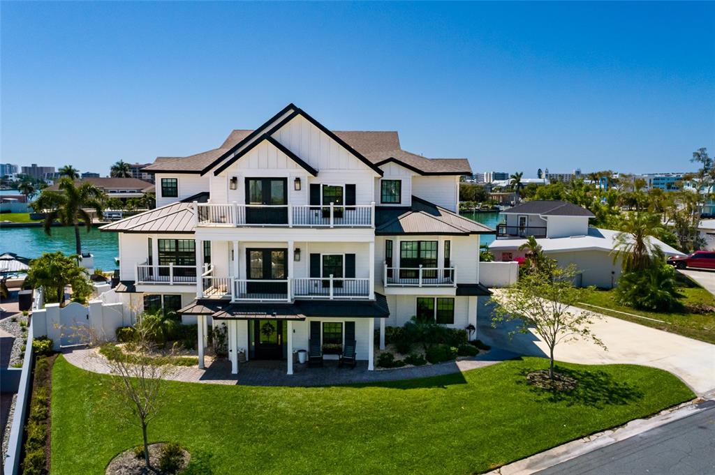 An aerial view of a three-story white house with black trim and a metal roof — 5408 PALI WAY, ST PETE BEACH, FL
