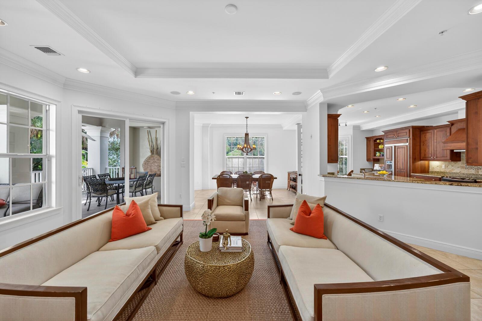 A living room with two sofas, a coffee table, and an open view to the dining area — VERO BEACH, FL