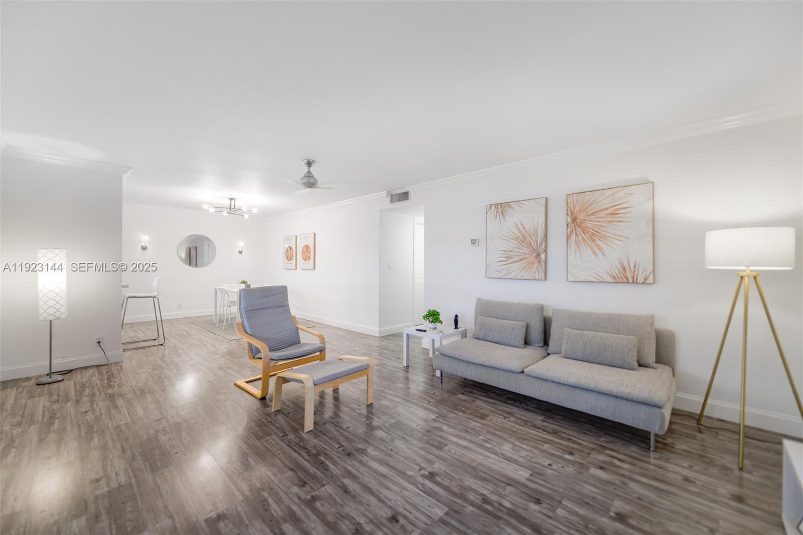 A living room features light gray wood-look flooring, a sofa, an armchair, and white walls — 200 NE 12th Ave # 6D, Hallandale Beach FL 33009, HALLANDALE BEACH, FL