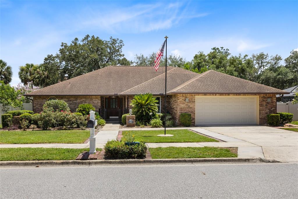 A single-story brick house with a hip roof, a two-car garage, and a front lawn — 4209 LORI LOOP, WINTER SPRINGS, FL