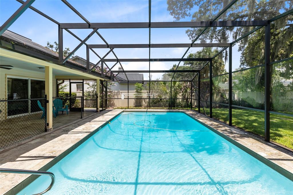 A rectangular swimming pool enclosed by a screened lanai with a covered patio area — 4209 LORI LOOP, WINTER SPRINGS, FL