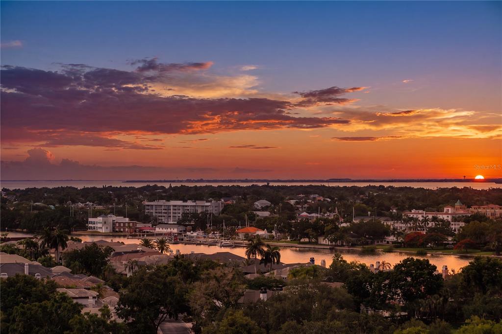 An aerial view of a waterfront neighborhood at sunset with a marina and distant horizon — 450 KNIGHTS RUN AVENUE UNIT 1208, TAMPA, FL