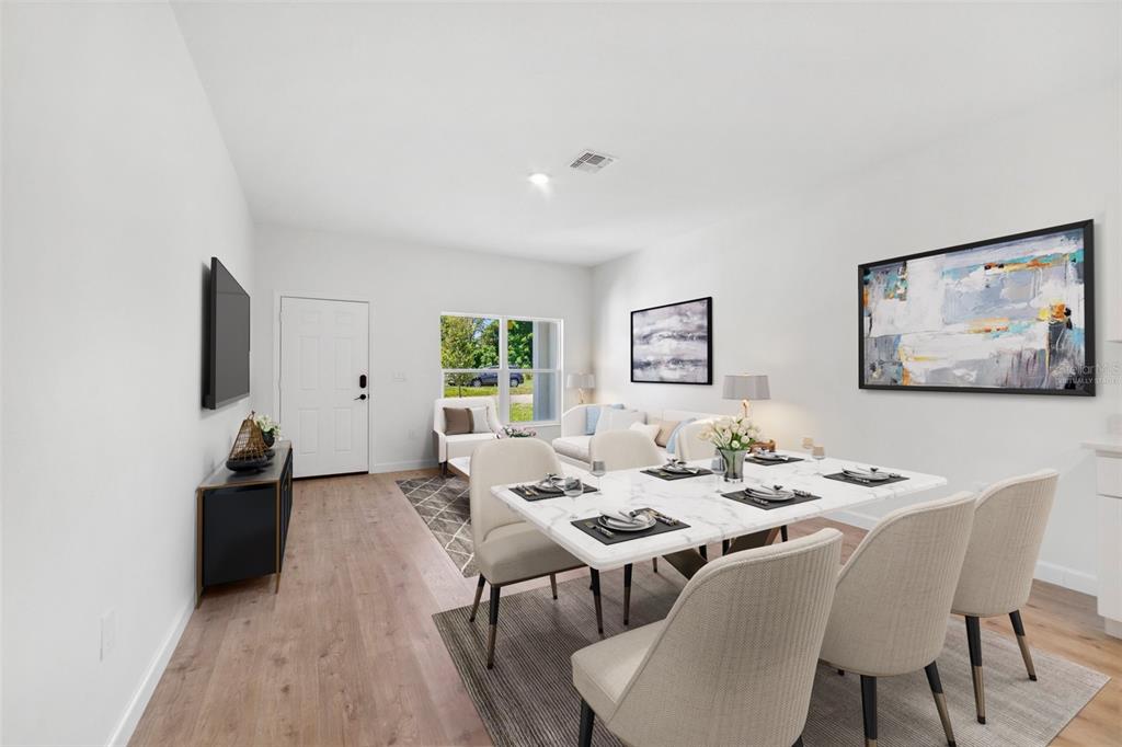 A dining area with a marble table and chairs sits adjacent to a living room — 1724 ELIZABETH AVENUE, TITUSVILLE, FL