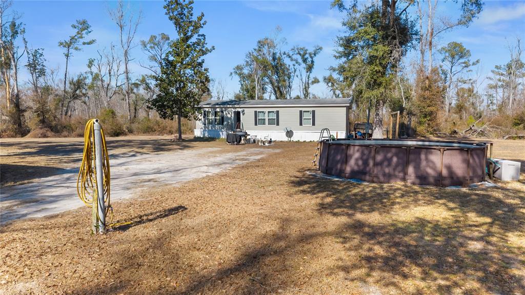 A manufactured home sits on a large lot with a round above-ground swimming pool — 1650 W LYMAN HENDRY ROAD UNIT 1, PERRY, FL