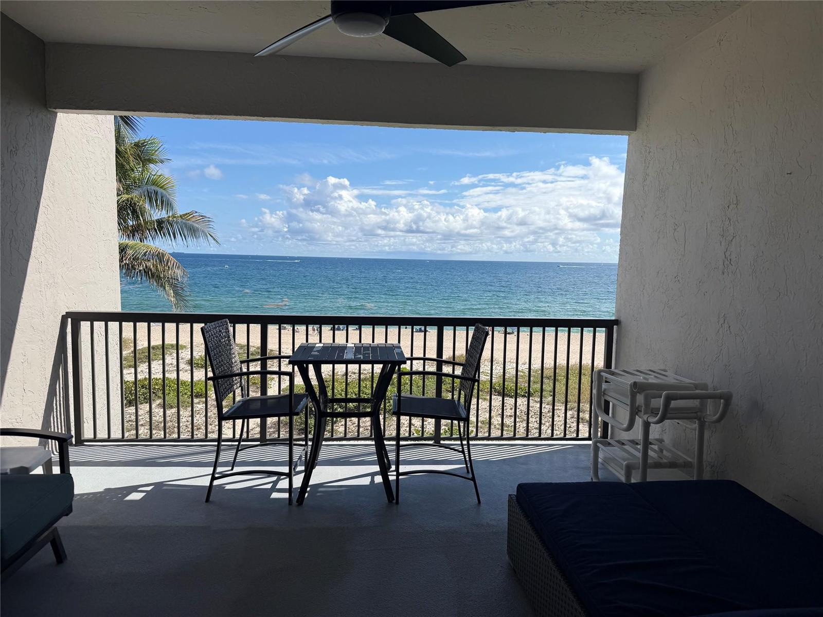 A covered balcony features a small dining set overlooking a sandy beach and the ocean — 520 N Ocean Boulevard # 13, Pompano Beach FL 33062, POMPANO BEACH, FL
