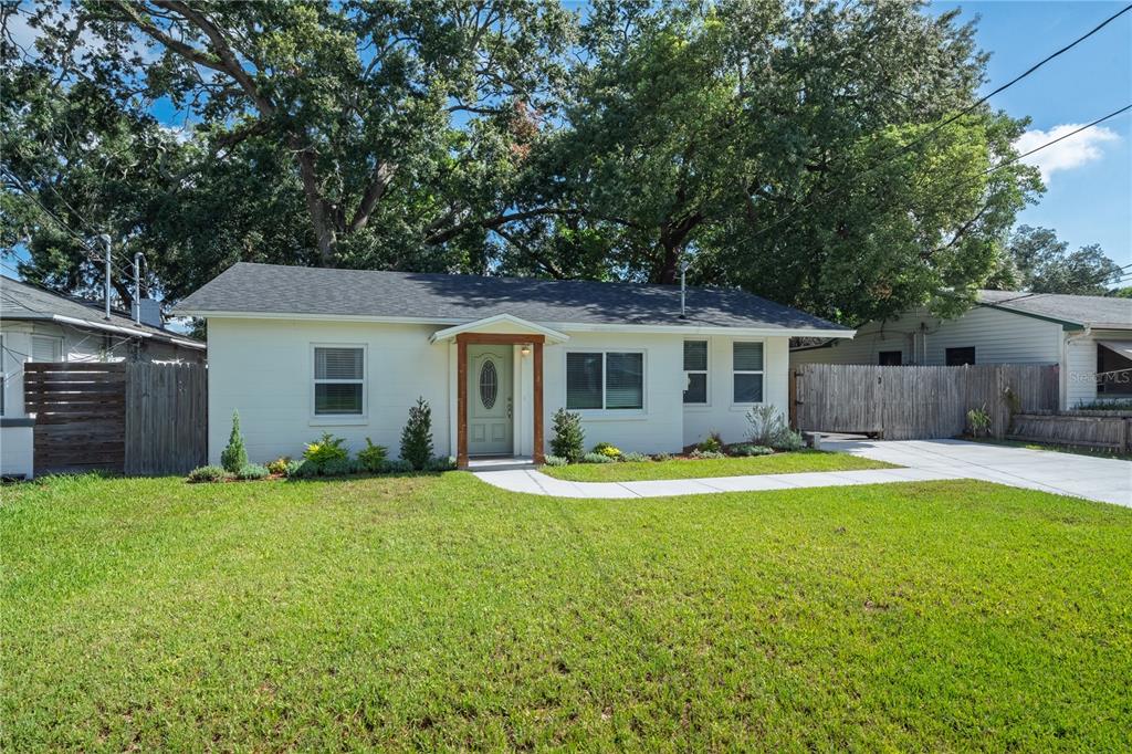 A single-story white house with a gabled entryway and a front lawn — 915 DOWD AVENUE, ORLANDO, FL