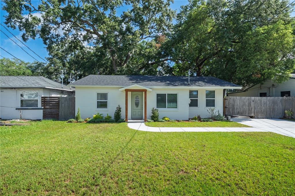 A single-story white house with a light green front door and a concrete walkway — 915 DOWD AVENUE, ORLANDO, FL