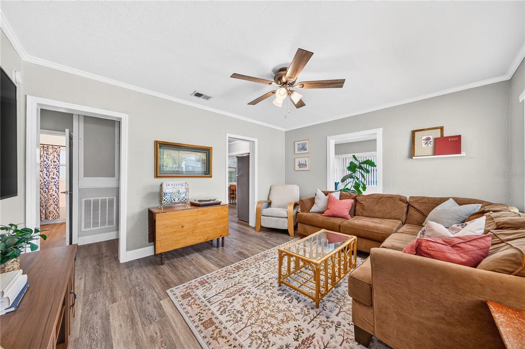 A living room features a brown sectional sofa, a patterned rug, and a ceiling fan — 915 DOWD AVENUE, ORLANDO, FL