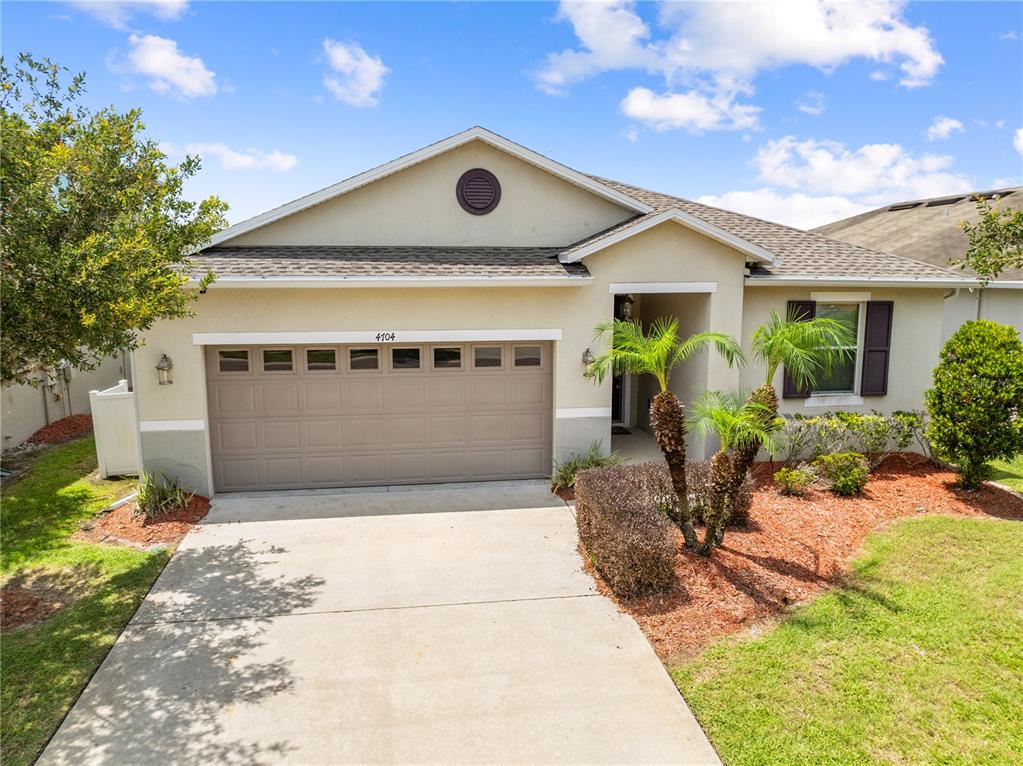 A single-story house features a two-car garage, a concrete driveway, and a small front yard — 4704 RUBY RED LANE, KISSIMMEE, FL