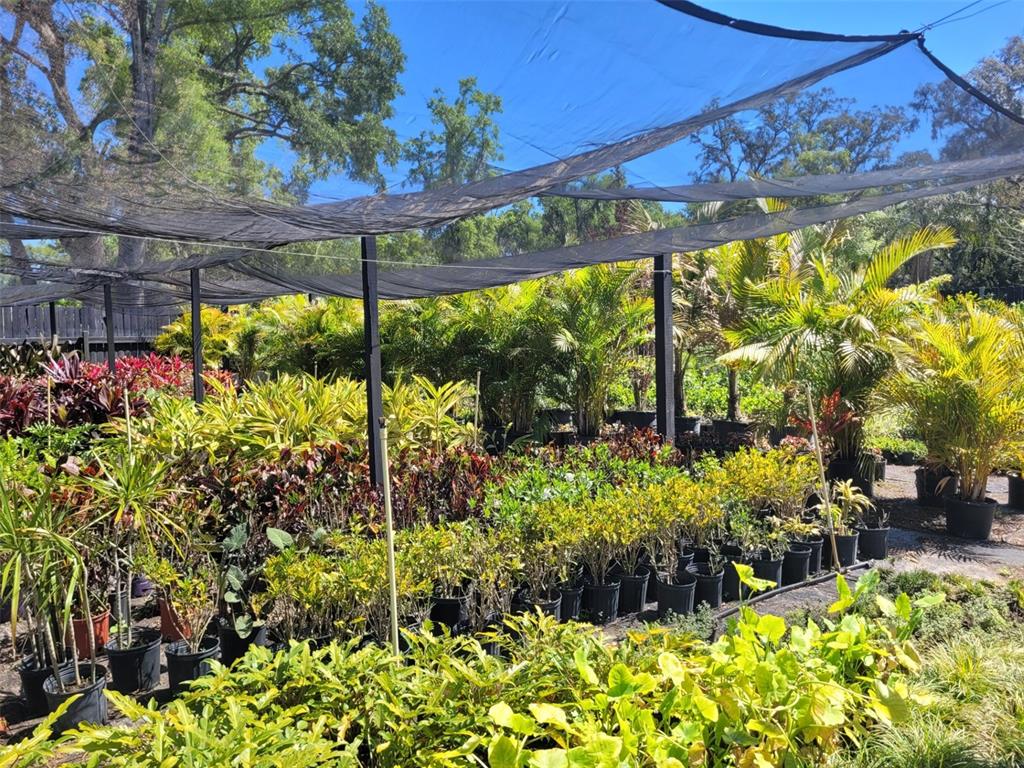 A nursery area features rows of potted plants under a large black shade cloth canopy — 7513 EDGEWATER DRIVE, ORLANDO, FL