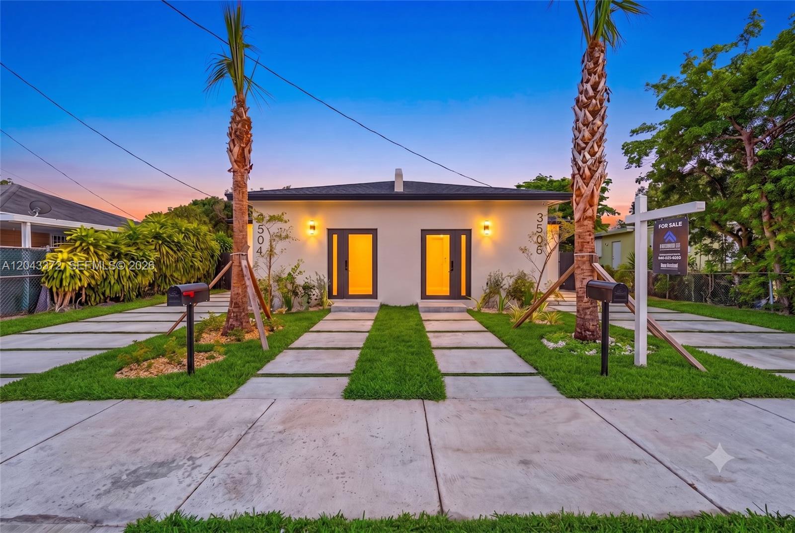 A modern duplex with two front doors, palm trees, and concrete driveways at dusk — 3506 NW 9th Ave, Miami FL 33127, MIAMI, FL
