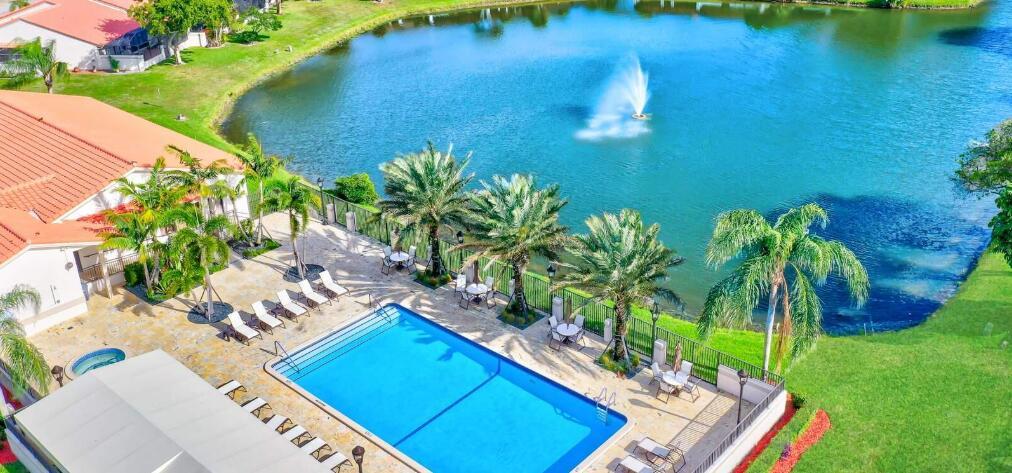 An aerial view of a swimming pool and patio area next to a lake — 20020 Rima Circle, Boca Raton FL 33434, BOCA RATON, FL