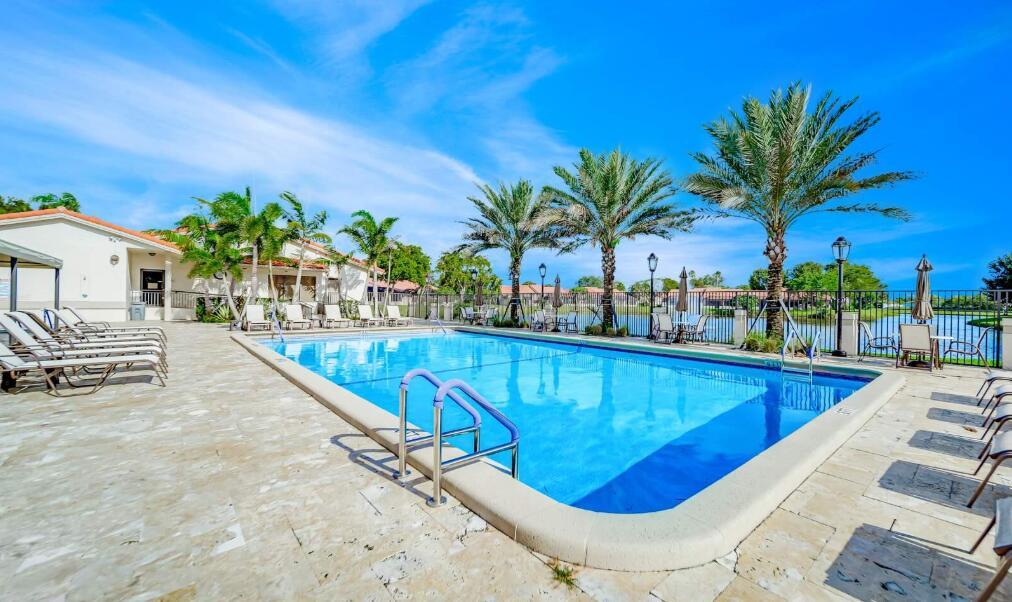 A rectangular swimming pool with lounge chairs and palm trees on a sunny patio — 20020 Rima Circle, Boca Raton FL 33434, BOCA RATON, FL