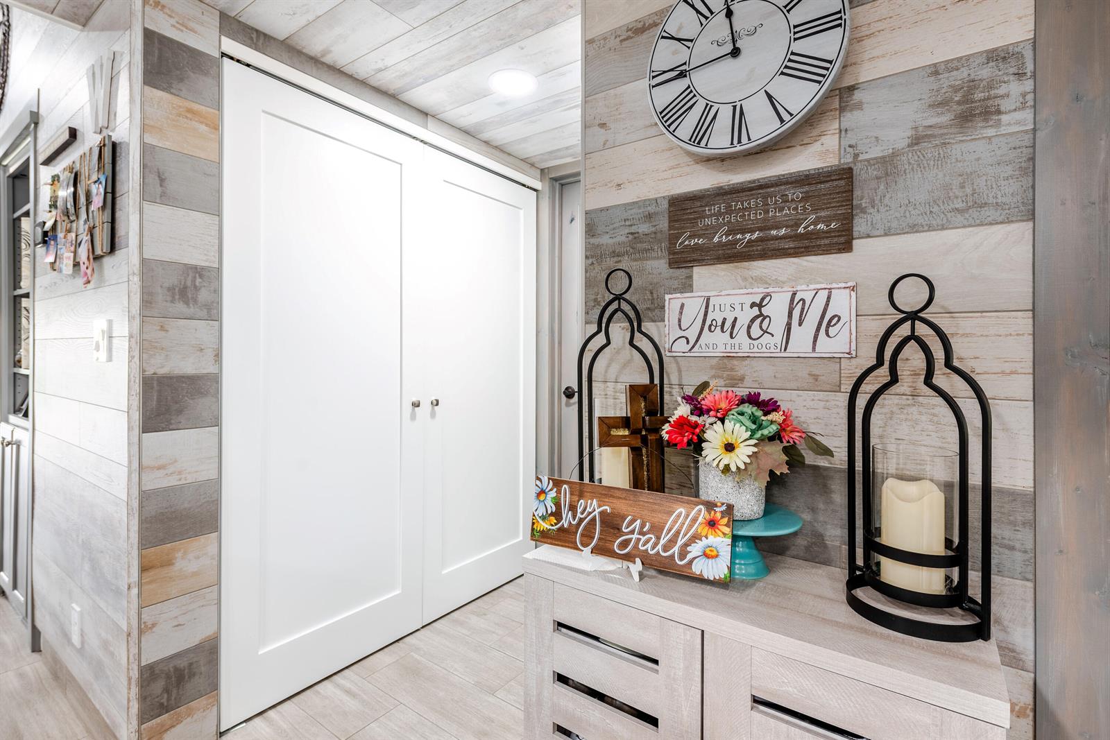 A hallway features wood-plank walls, a white double-door closet, and a console table with decor — 7418 Victory Lane # 9805, Delray Beach FL 33446, DELRAY BEACH, FL