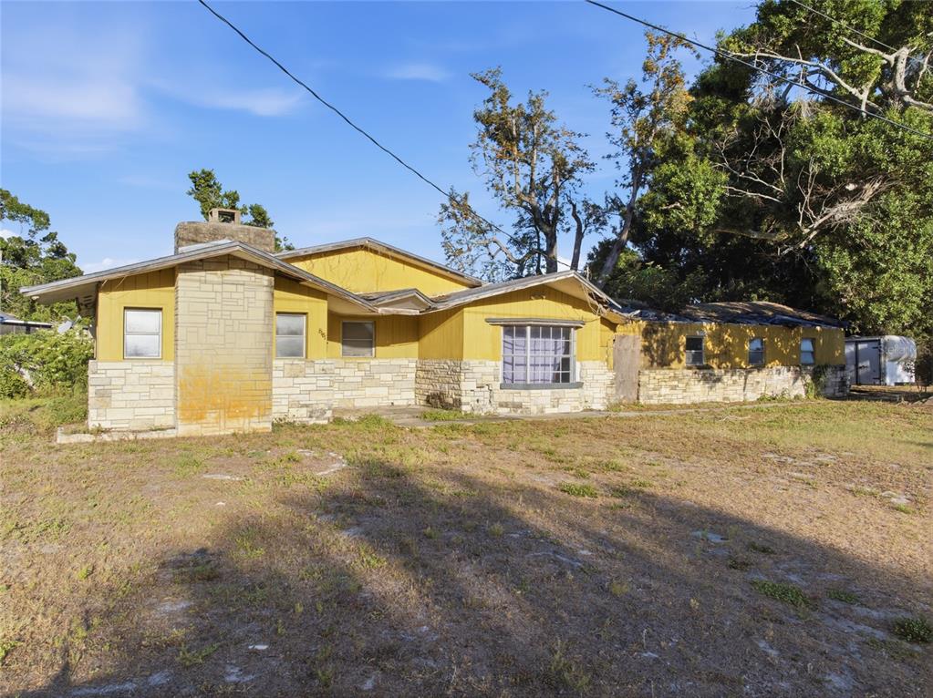 A single-story house with yellow siding and a stone facade sits on a grassy lot — 8181 61ST LANE N, PINELLAS PARK, FL