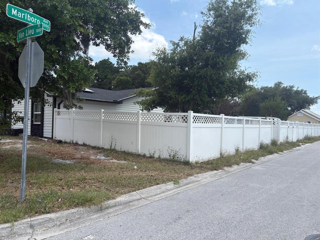 A white vinyl fence encloses a house at the corner of two residential streets — 1010 VAN LIEU STREET, KISSIMMEE, FL
