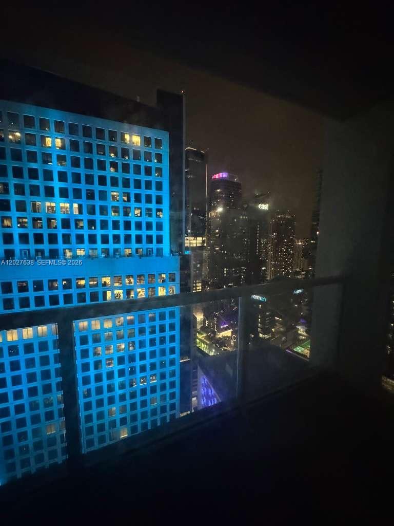 A night view from a balcony overlooking illuminated city skyscrapers and urban buildings — 500 Brickell Ave # 3910, Miami FL 33131, MIAMI, FL