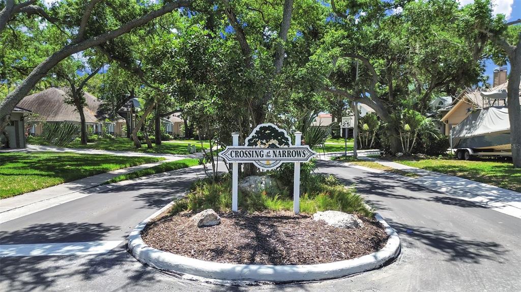 A sign for Crossing at the Narrows stands in a landscaped island between two roads — 7645 HARBOR VIEW WAY, SEMINOLE, FL