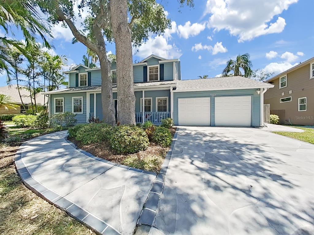 A two-story blue house with a two-car garage and a curved concrete driveway — 7645 HARBOR VIEW WAY, SEMINOLE, FL
