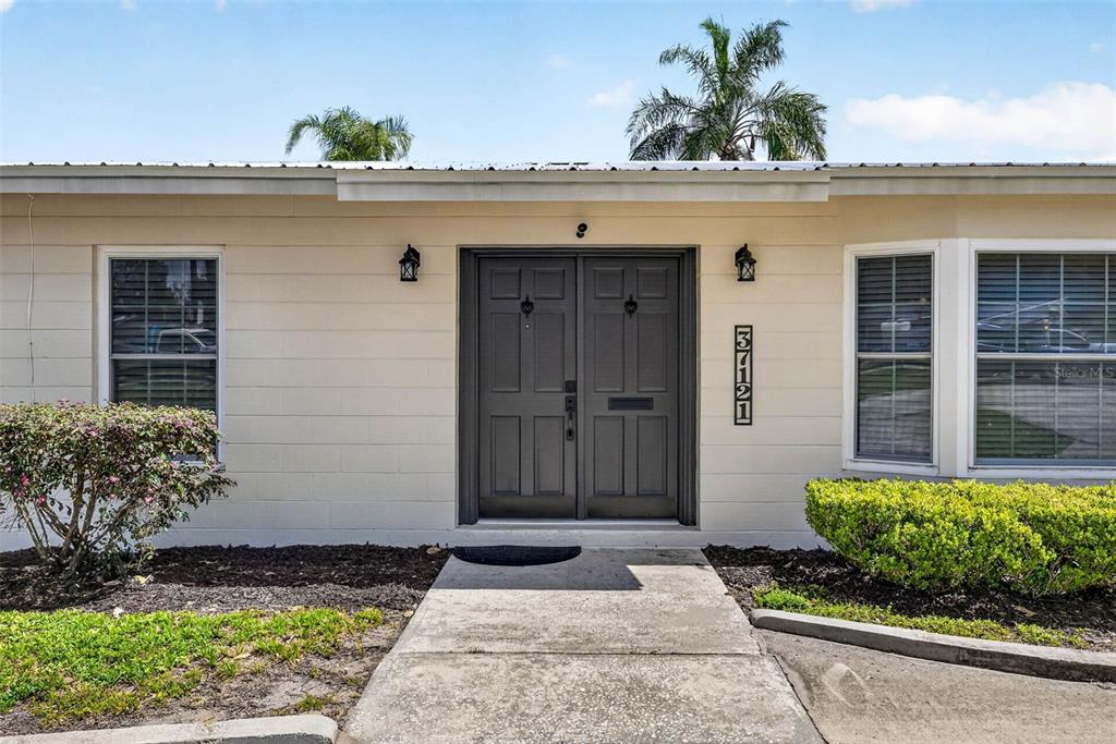 The exterior of a single-story house features a double front door and a concrete walkway — 37121 MERIDIAN AVENUE, DADE CITY, FL