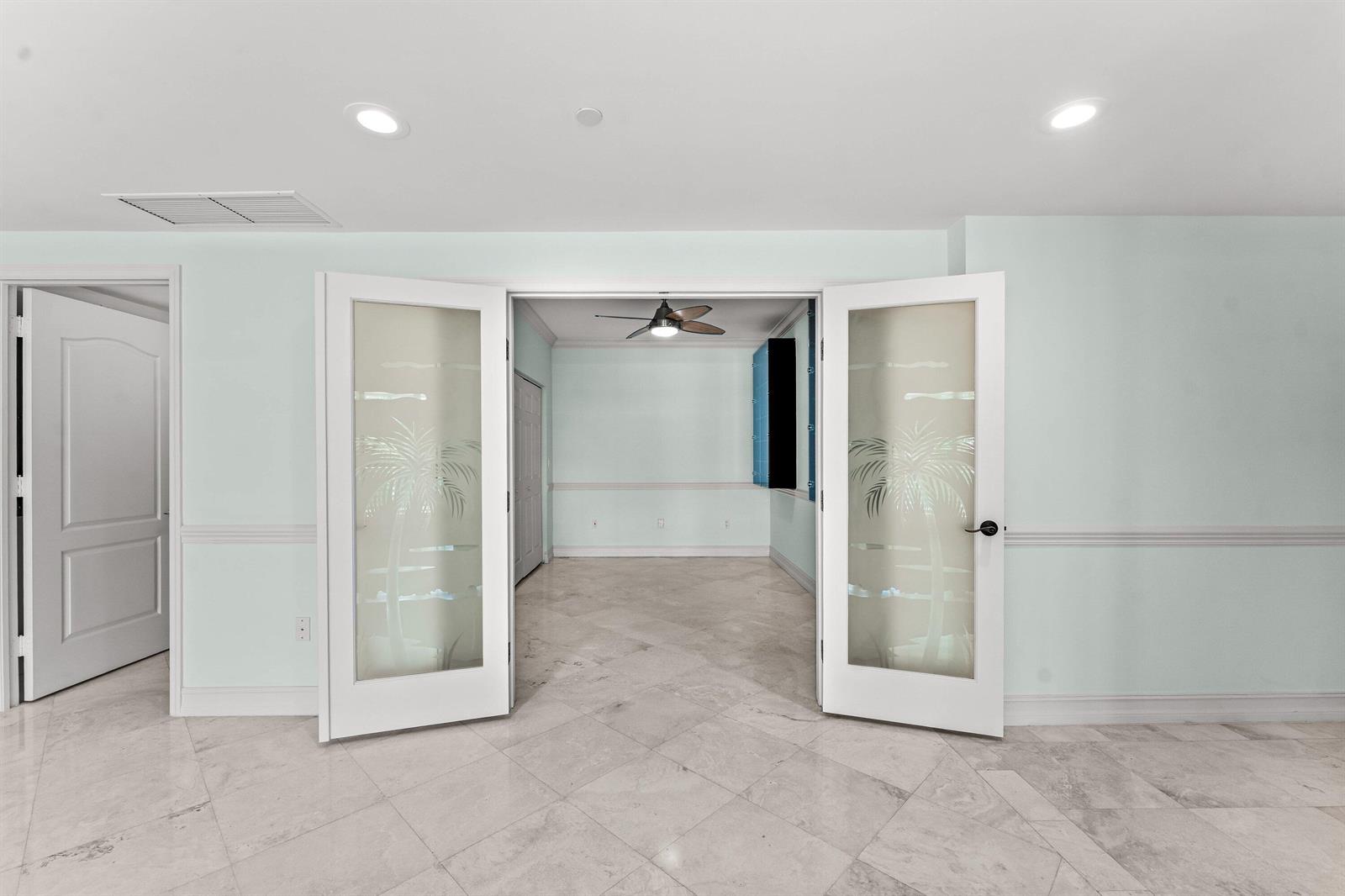 A room with light blue walls and marble tile floors features glass-paneled double doors — 550 SE Mizner Boulevard # B501, Boca Raton FL 33432, BOCA RATON, FL