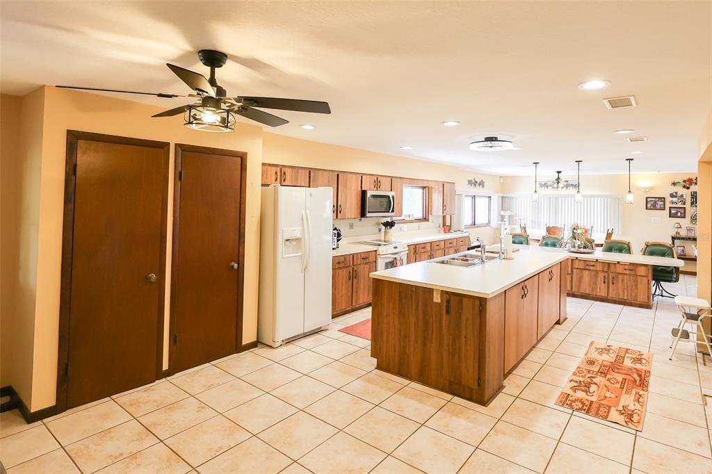 An entryway features a brick wall, a wooden door with sidelights, and a rustic chandelier — 5757 TRASK ROAD, FORT MEADE, FL