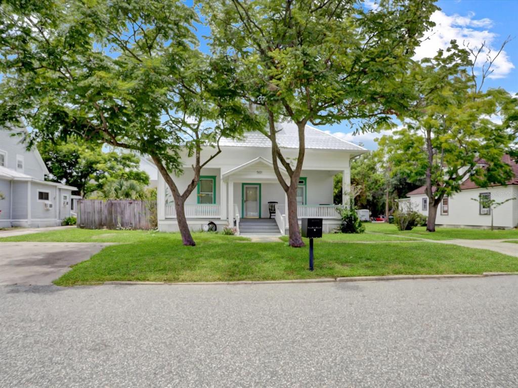 A white, two-story house with a front porch, a dormer window, and a metal roof — 501 SUMNER STREET, KISSIMMEE, FL