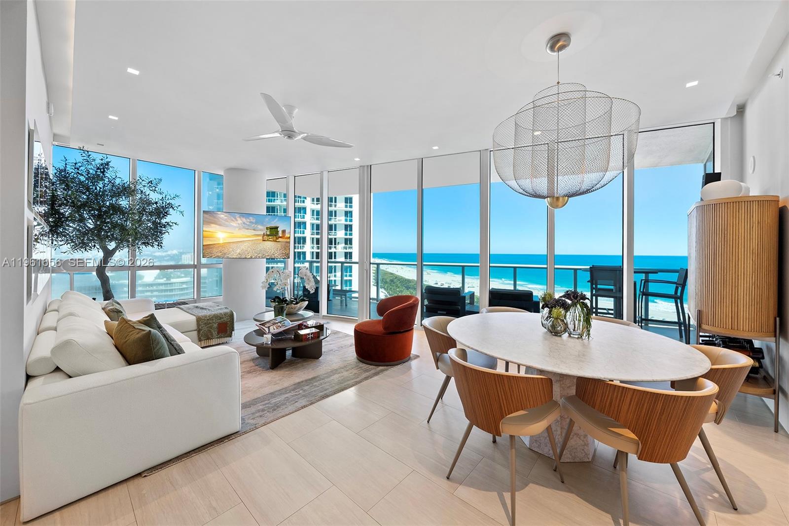 A bright, modern living and dining room features floor-to-ceiling windows with ocean views — 100 S Pointe Dr, Miami Beach FL 33139, MIAMI BEACH, FL