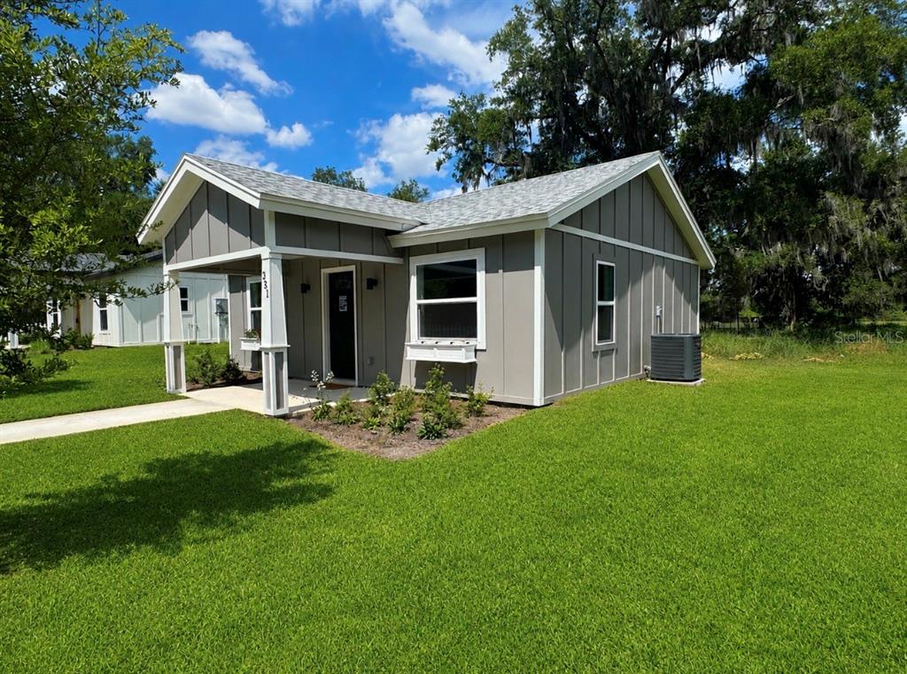 A gray, single-story house with board-and-batten siding and a covered front porch — 351 N MAIN AVENUE, GROVELAND, FL