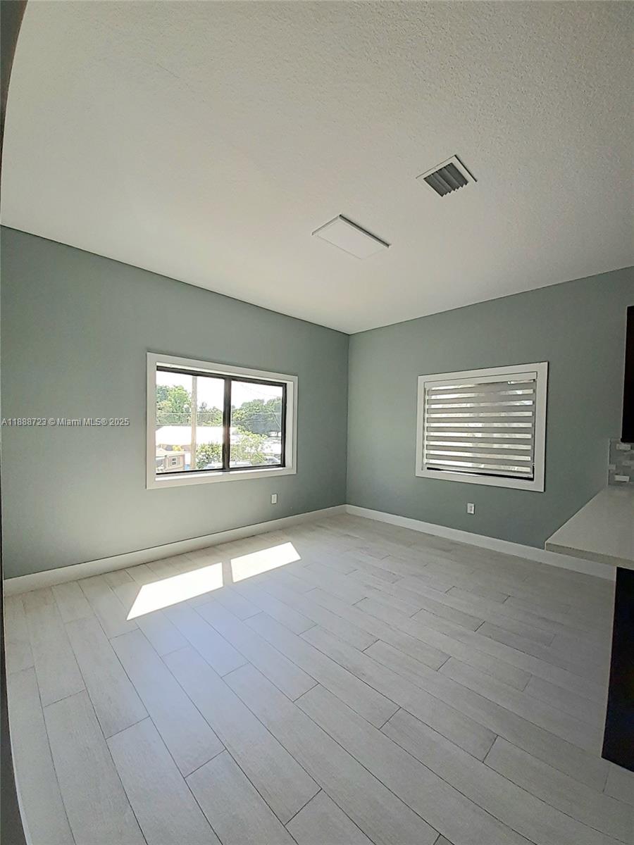 A room with light gray walls, white wood-look flooring, and two windows — 23 Jenny Ln, Key Largo FL 33037, KEY LARGO, FL