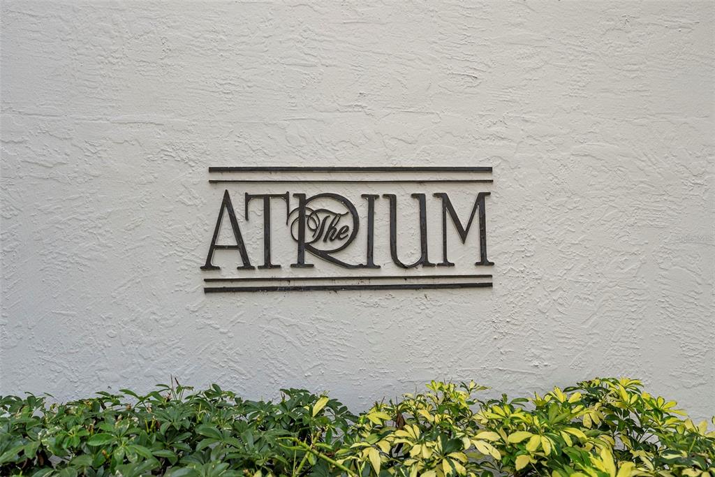 A metal sign reading The Atrium is mounted on a textured white exterior wall — 2413 BAYSHORE BOULEVARD UNIT 803, TAMPA, FL
