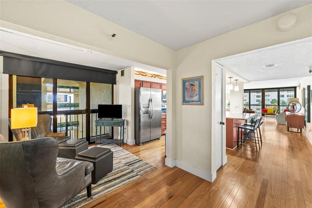 A living area with hardwood floors leads into a kitchen and a bright dining space — 2413 BAYSHORE BOULEVARD UNIT 803, TAMPA, FL