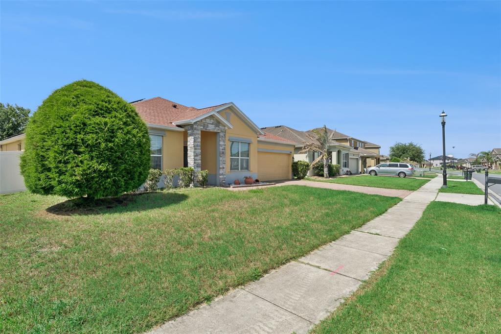 A single-story suburban house with a stone-accented entryway and a large, rounded front yard tree — 3409 BRANT STREET, ST CLOUD, FL