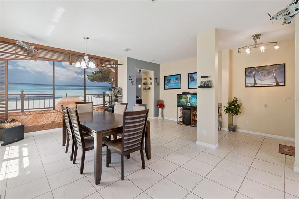 A dining room features a large beach mural, tile flooring, and a wooden table set — 3409 BRANT STREET, ST CLOUD, FL