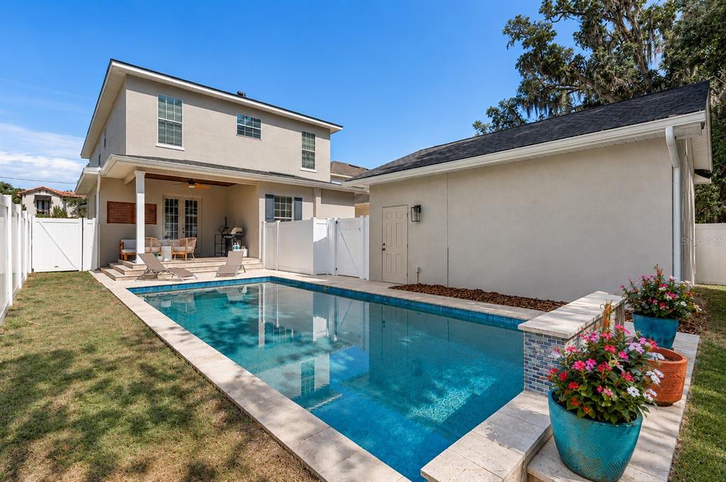 A backyard features a rectangular swimming pool, a covered patio, and a detached garage — 1900 GERDA TERRACE, ORLANDO, FL