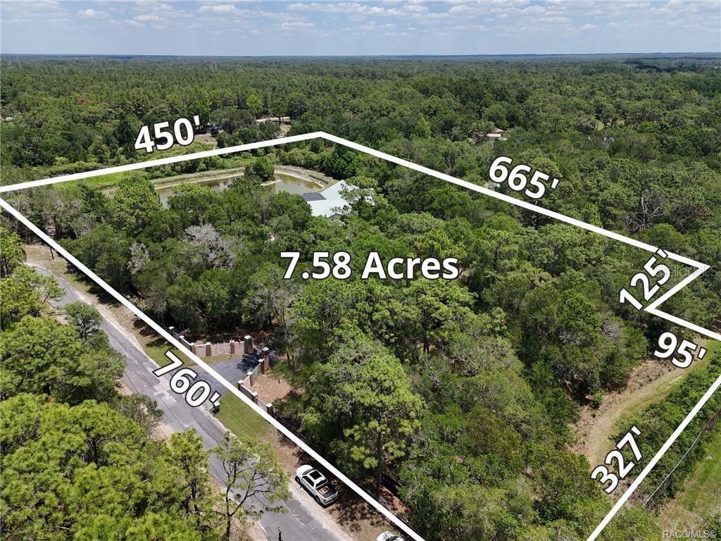 This aerial view shows a wooded property with a house and pond outlined in white — 5215 N HONEYCREEK TERRACE, CRYSTAL RIVER, FL