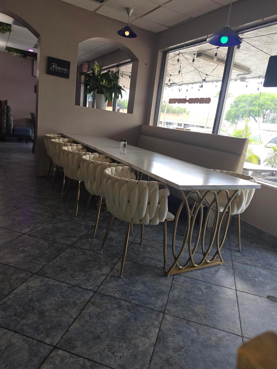A restaurant dining area features a long white table with gold-based chairs and tile flooring — 6685 Lake Worth Road, FL 33467, FL