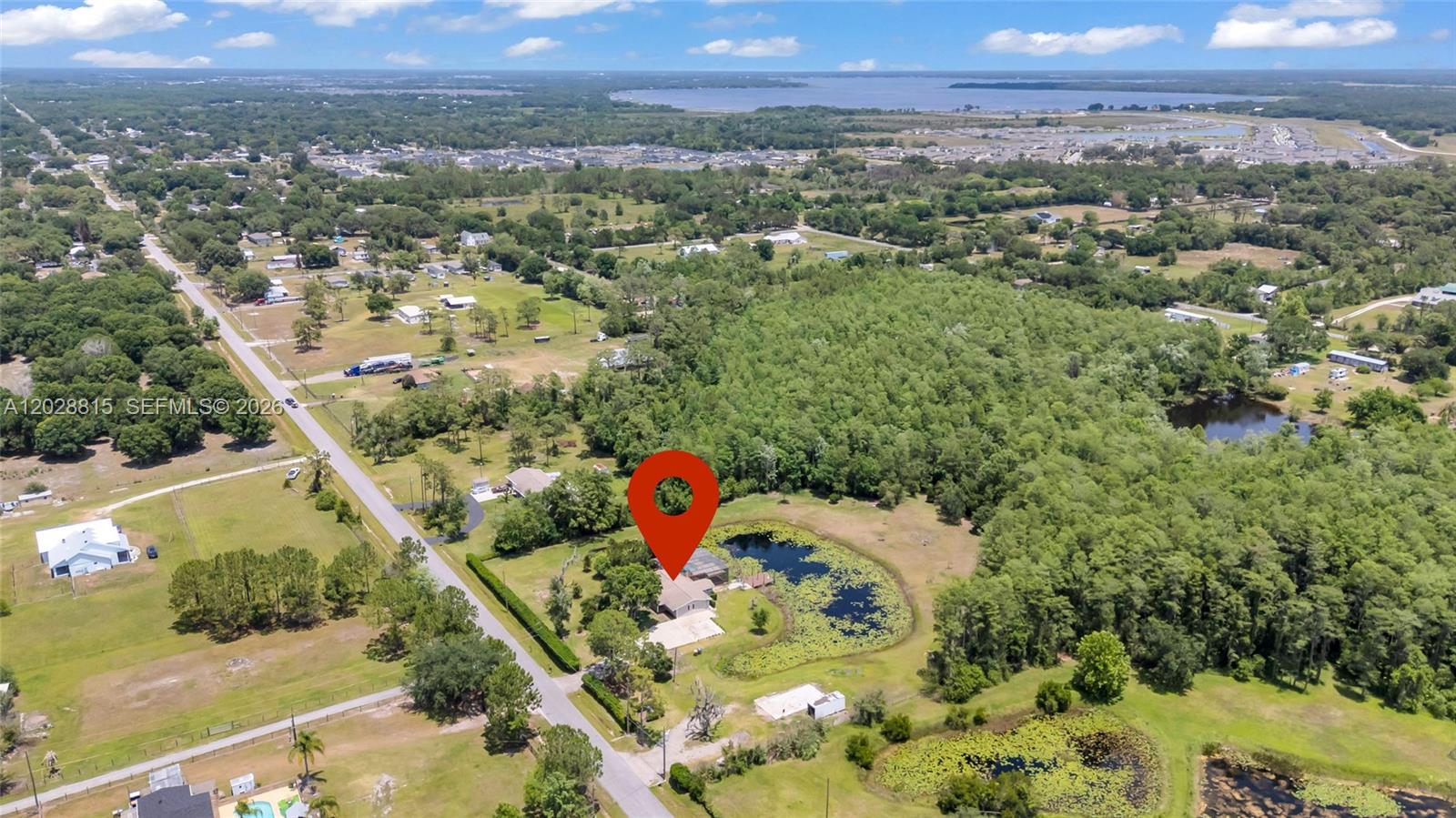 An aerial view shows a house with a pond on a large, wooded rural lot — 4125 rambler avenue, Saint Cloud FL 34772, SAINT CLOUD, FL
